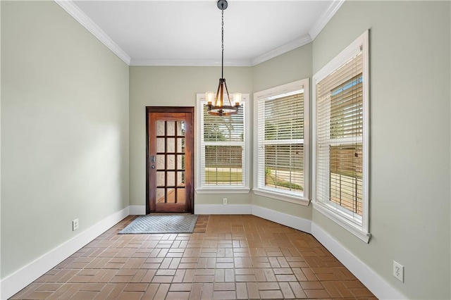 entryway with an inviting chandelier and crown molding