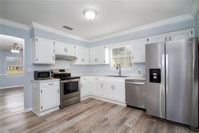 kitchen featuring under cabinet range hood, stainless steel appliances, a sink, white cabinets, and light countertops