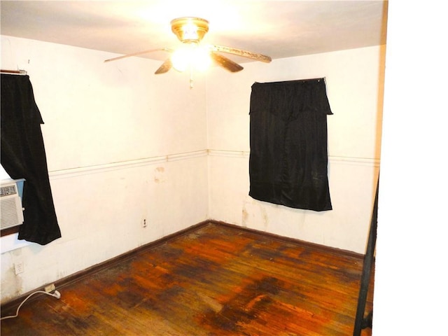 empty room with ceiling fan and dark hardwood / wood-style flooring