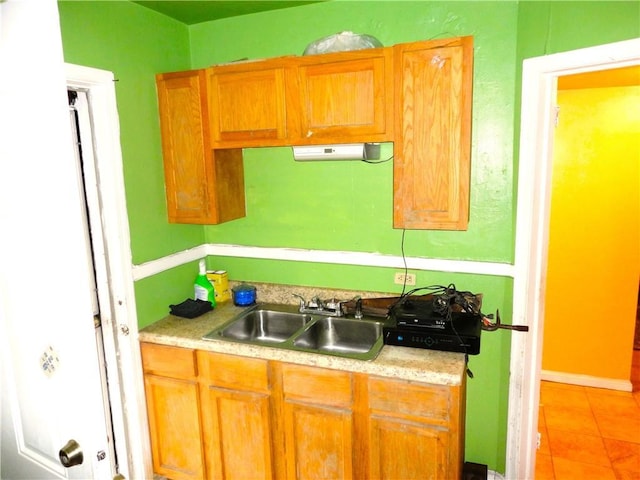 kitchen featuring light tile patterned floors and sink