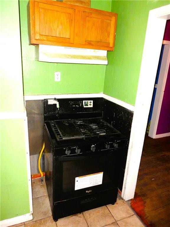 kitchen with black gas stove and light tile patterned floors