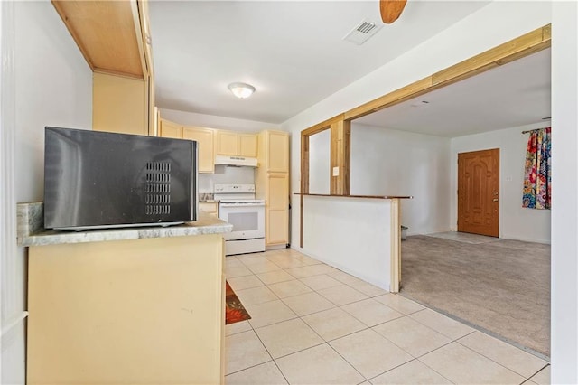 kitchen featuring light carpet, white electric range oven, light tile patterned floors, light countertops, and under cabinet range hood