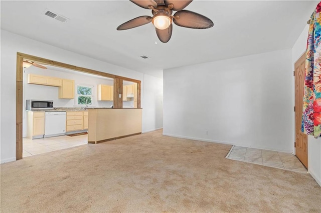 unfurnished living room with a ceiling fan, light colored carpet, visible vents, and light tile patterned flooring