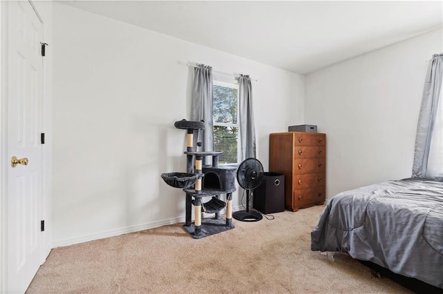 bedroom with baseboards and light colored carpet