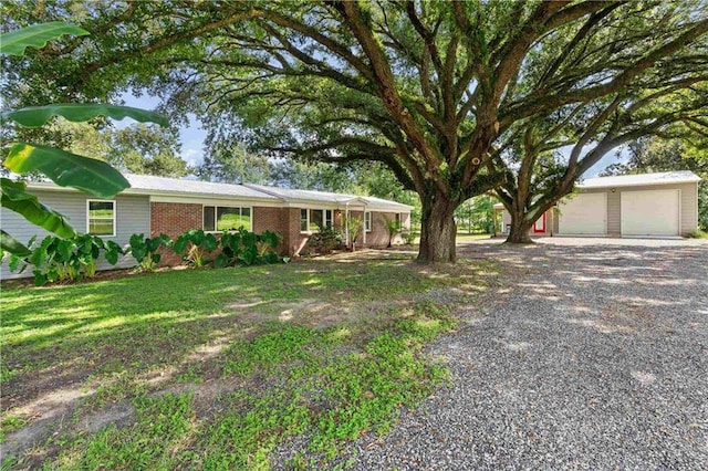 single story home featuring a garage, a front yard, and brick siding