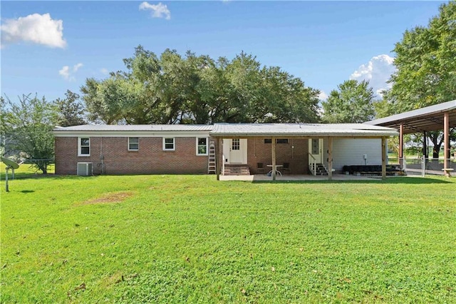 back of property with brick siding, a yard, a patio, entry steps, and central AC