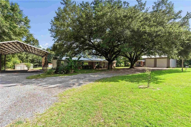 view of yard featuring a carport and an outbuilding