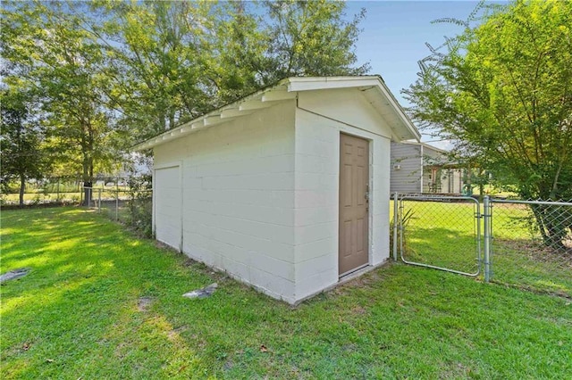 view of outdoor structure featuring a gate, fence, and an outbuilding