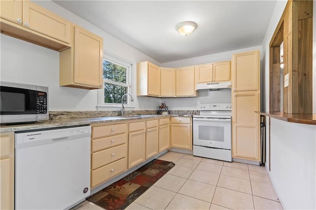 kitchen featuring light tile patterned floors, light brown cabinets, under cabinet range hood, white appliances, and a sink