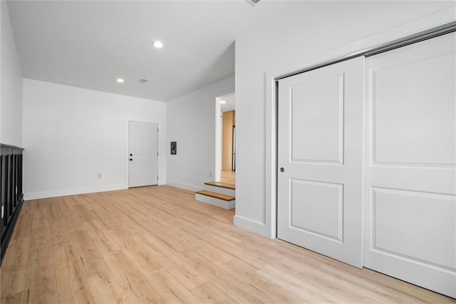 unfurnished bedroom with light wood-type flooring and a closet