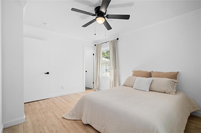 bedroom with ceiling fan, hardwood / wood-style floors, and crown molding