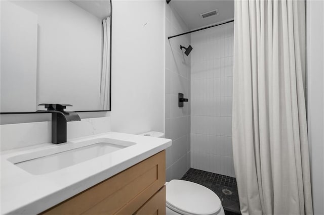 bathroom featuring vanity, toilet, and walk in shower