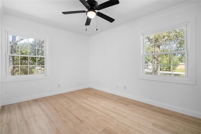 empty room with ceiling fan, ornamental molding, a healthy amount of sunlight, and light wood-type flooring