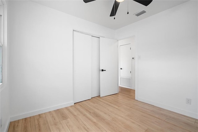 unfurnished bedroom with a closet, light hardwood / wood-style flooring, and ceiling fan