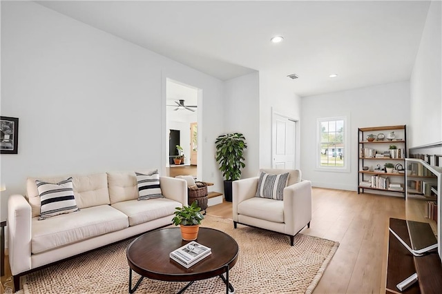 living room with light wood-type flooring and ceiling fan