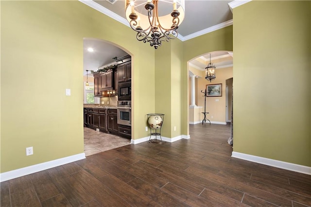 tiled empty room with ornamental molding, a notable chandelier, and a raised ceiling