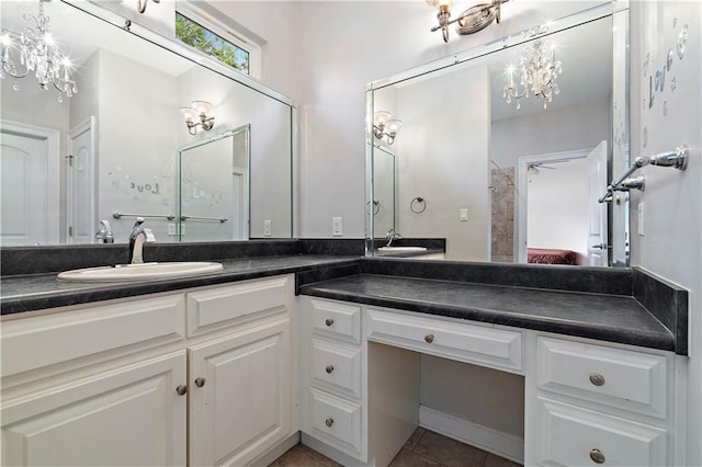 bathroom featuring vanity with extensive cabinet space, dual sinks, an inviting chandelier, and tile flooring