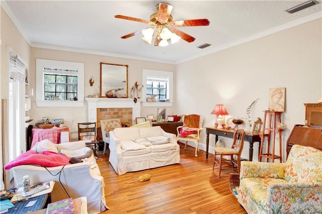 living room with light wood-type flooring, a wealth of natural light, and crown molding