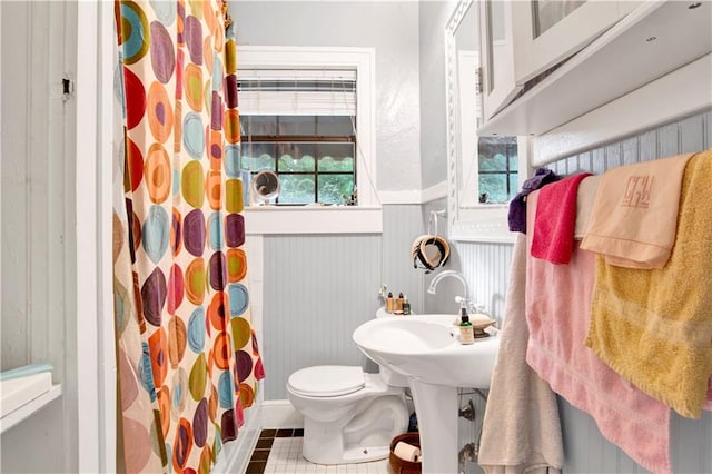 bathroom with tile patterned floors, toilet, and a shower with shower curtain