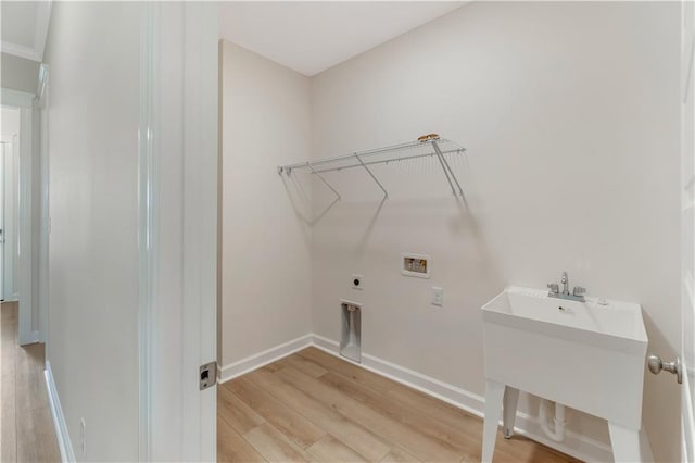 laundry room with laundry area, baseboards, hookup for a washing machine, electric dryer hookup, and light wood-style flooring