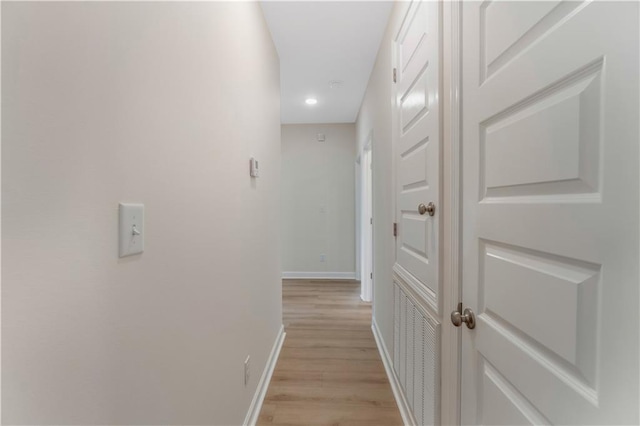 hallway with baseboards, recessed lighting, and light wood-style floors