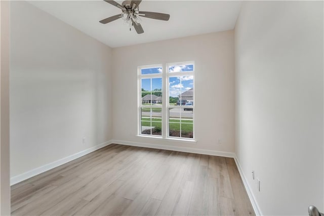 spare room with a ceiling fan, baseboards, and light wood-style floors