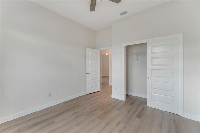 unfurnished bedroom with light wood-style flooring, a ceiling fan, baseboards, visible vents, and a closet