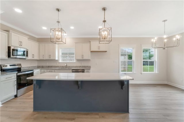 kitchen featuring crown molding, a sink, appliances with stainless steel finishes, and a notable chandelier