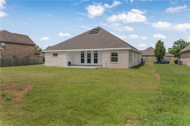 rear view of property featuring fence, roof with shingles, a patio area, french doors, and a yard