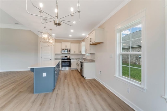 kitchen featuring an inviting chandelier, baseboards, crown molding, and stainless steel appliances