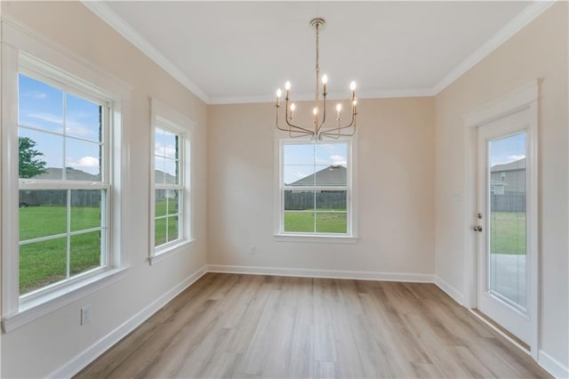 unfurnished dining area with baseboards, an inviting chandelier, ornamental molding, and light wood-style flooring