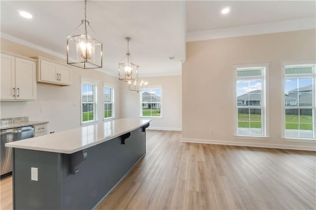 kitchen featuring light wood finished floors, dishwasher, light countertops, a chandelier, and ornamental molding