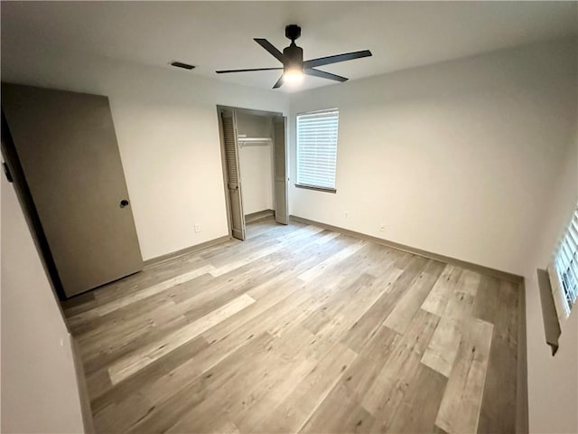 unfurnished bedroom featuring ceiling fan, a closet, and light hardwood / wood-style floors