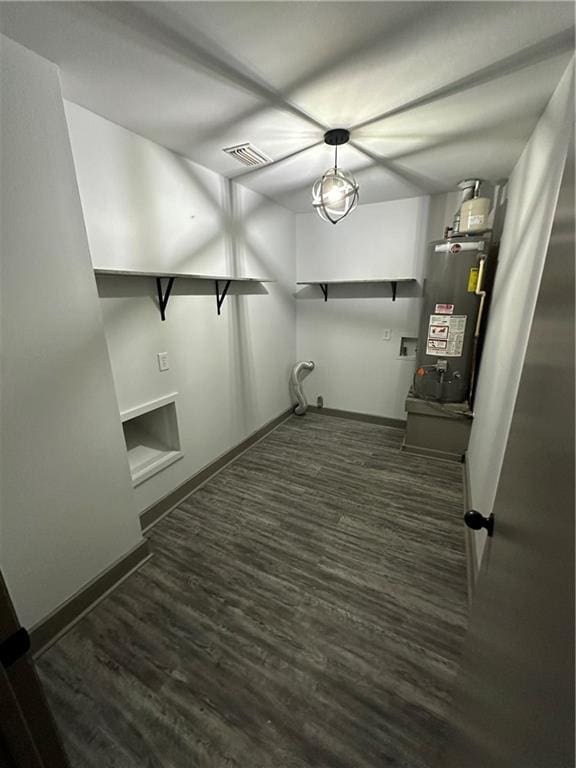 laundry area featuring dark hardwood / wood-style flooring and heating unit