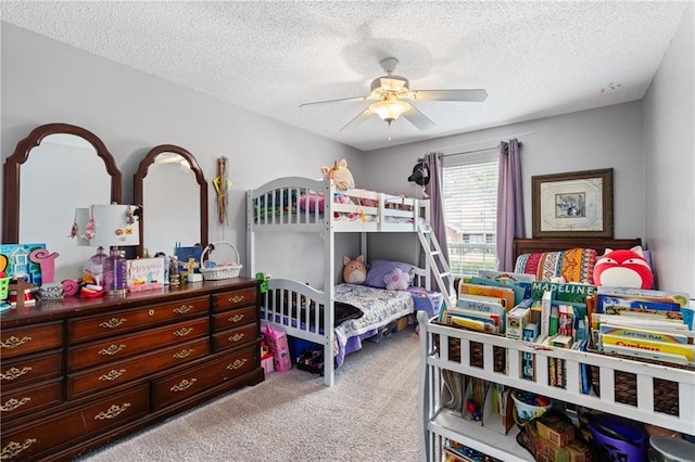 bedroom with ceiling fan, carpet floors, and a textured ceiling