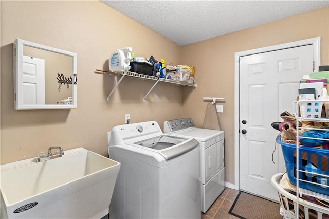 laundry room featuring sink, a textured ceiling, independent washer and dryer, and dark tile patterned flooring