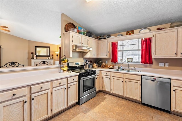 kitchen featuring sink, stainless steel appliances, a textured ceiling, vaulted ceiling, and light brown cabinets