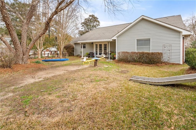 back of house featuring a yard and french doors