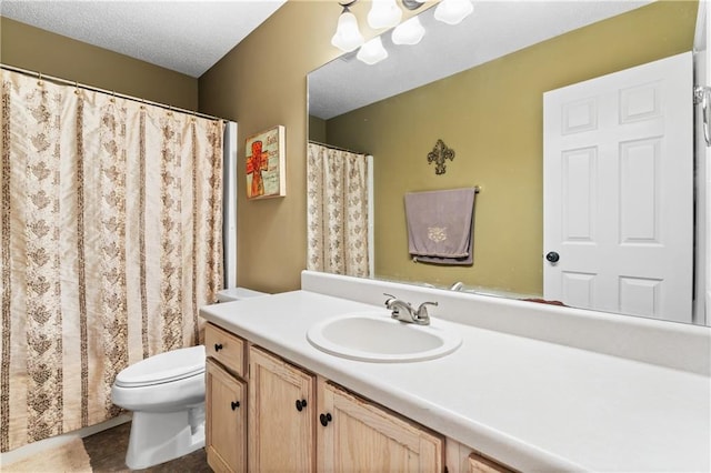 bathroom featuring vanity, toilet, and a textured ceiling