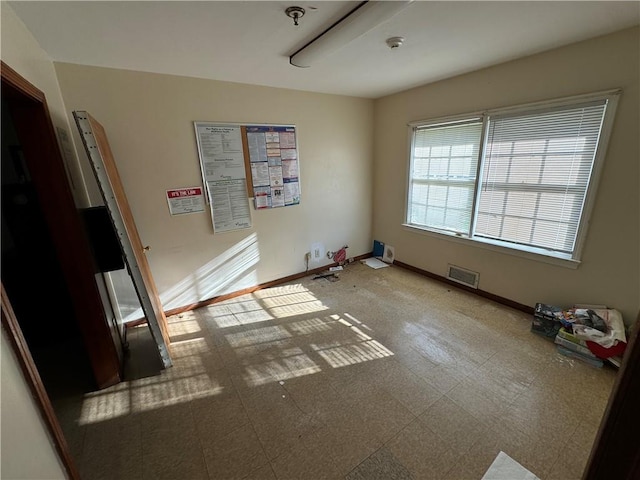 empty room featuring visible vents, baseboards, and tile patterned floors