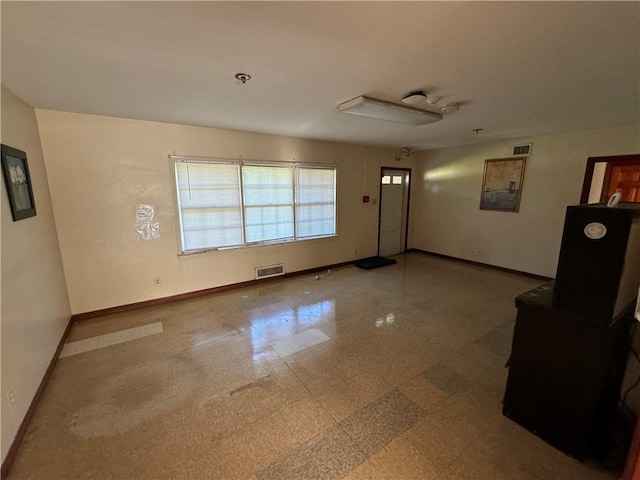 foyer entrance with visible vents and baseboards