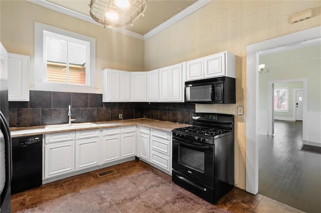kitchen featuring sink, crown molding, white cabinetry, tasteful backsplash, and black appliances