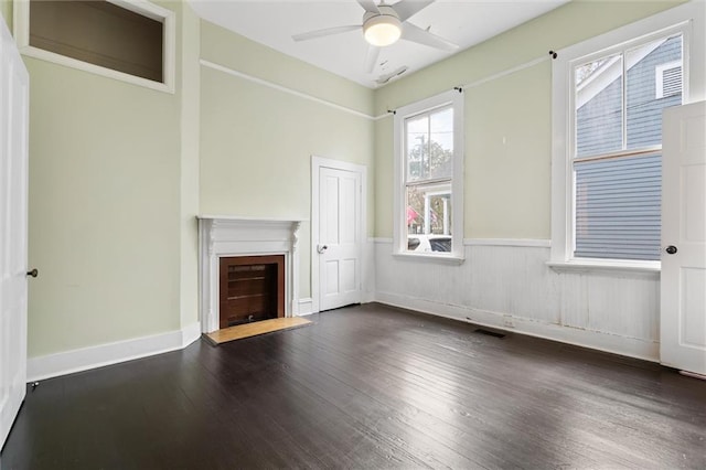 unfurnished living room with dark hardwood / wood-style flooring and ceiling fan