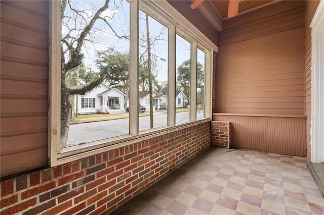 unfurnished sunroom with ceiling fan