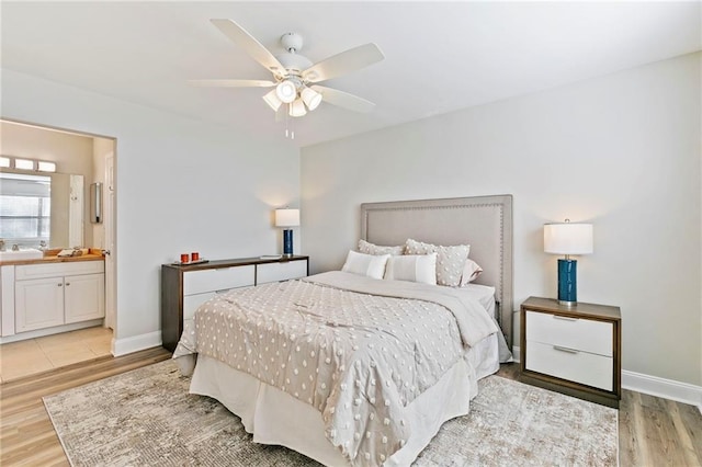 bedroom featuring sink, ceiling fan, connected bathroom, and light hardwood / wood-style flooring