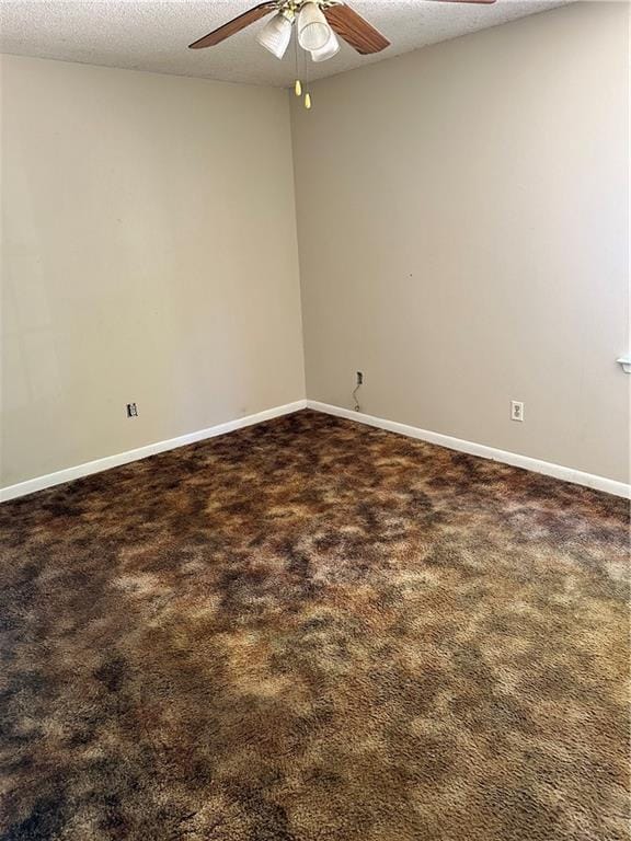 carpeted spare room featuring a textured ceiling and ceiling fan