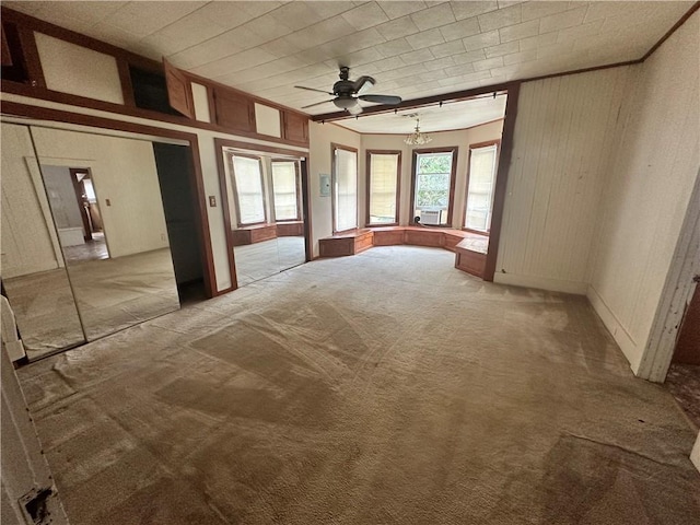 interior space featuring ceiling fan, carpet floors, and ornamental molding