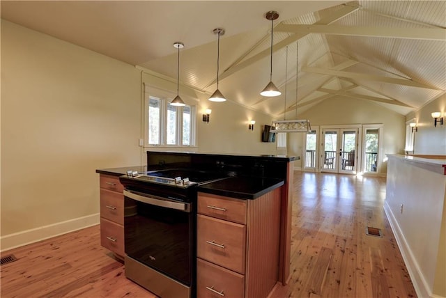 kitchen featuring vaulted ceiling with beams, plenty of natural light, and stainless steel range oven