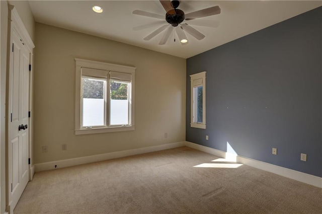 spare room featuring ceiling fan and light carpet