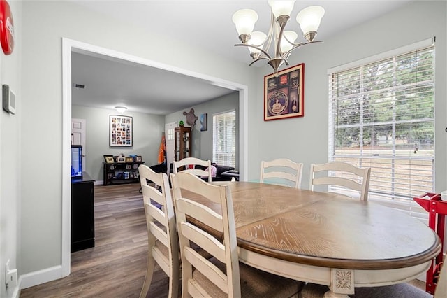 dining space with hardwood / wood-style flooring and a notable chandelier